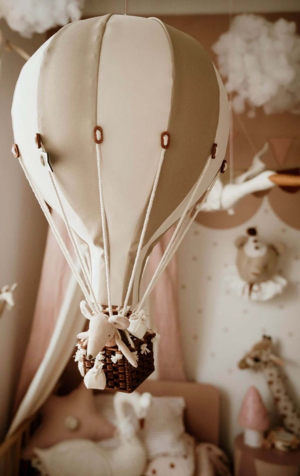 Inflatable hot air balloon decoration in a baby nursery with soft pastel colors, perfect for baby shower and gender reveal decor.