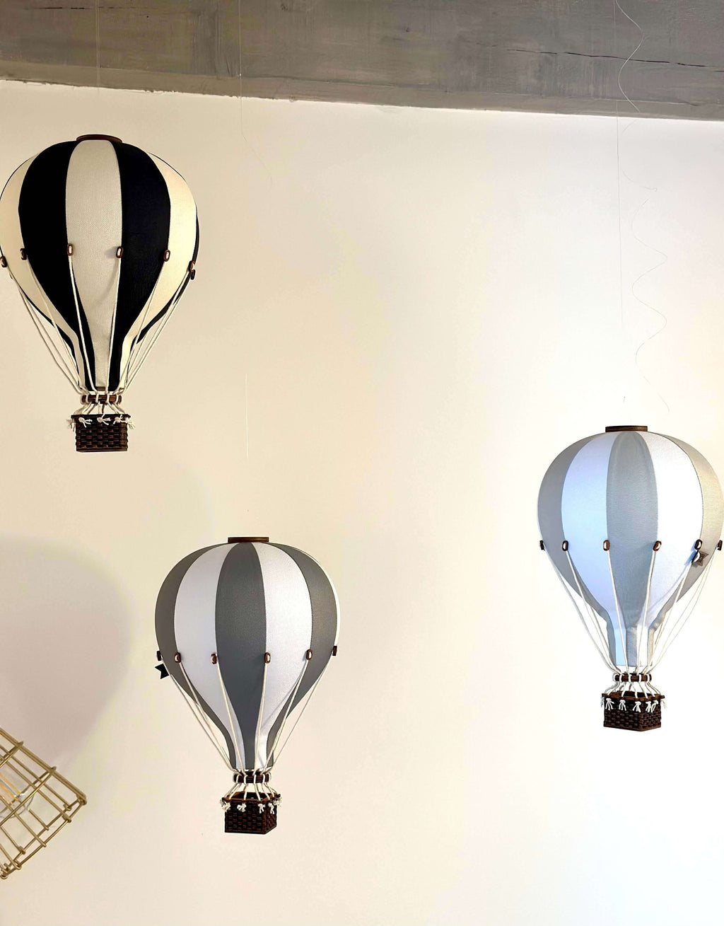 Inflatable hot air balloon decorations in white and dark grey for baby nursery and gender reveal decor.