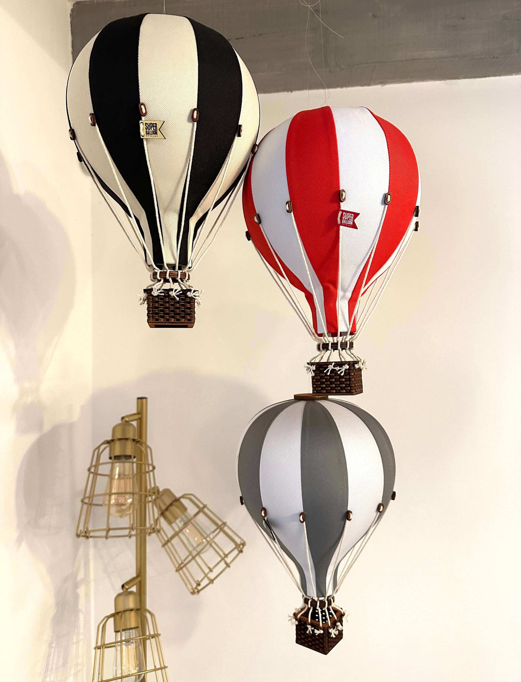 Inflatable hot air balloon decorations in black, red, and grey for baby shower, nursery, and gender reveal decor.