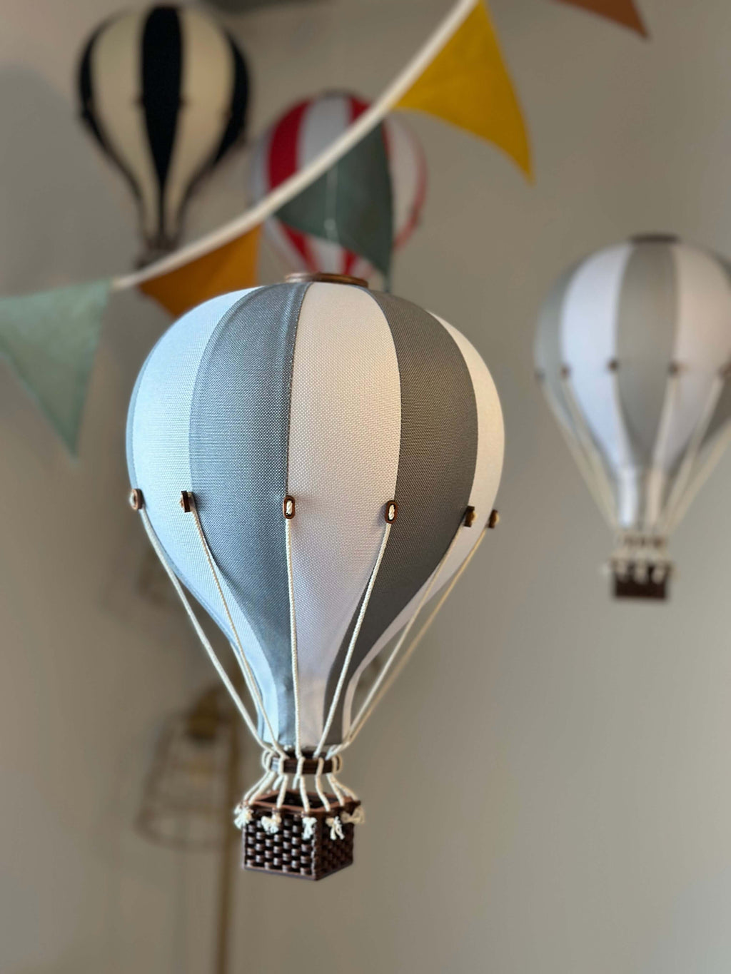 Inflatable hot air balloon decorations in white and dark grey for baby showers, nurseries, and gender reveal parties.