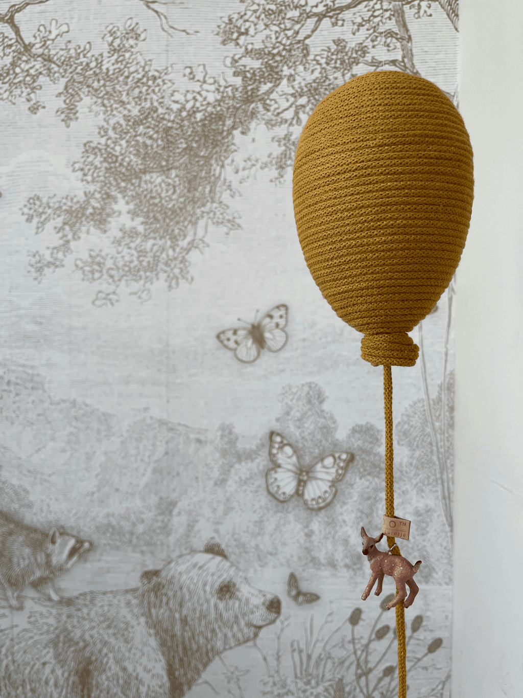 Ochre hot air balloon decoration with woodland mural backdrop for baby nursery décor.